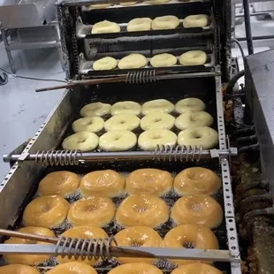 a conveyor belt full of doughnuts