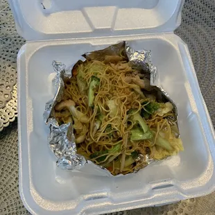 a takeout container with noodles and vegetables