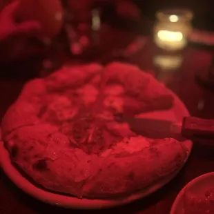 a pizza on a plate with a knife and fork