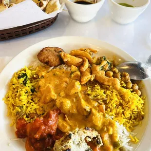 A color melange of flavorful curries atop several rices.  Pakoras and chutney.