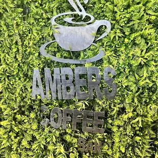 a cup of coffee in front of a green wall
