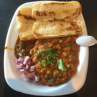 Pav bhaji. Green peas in a tomato onion sauce. Mango chilly pepper relish on the side.  I'd ask for idli instead of hotdog buns next time.