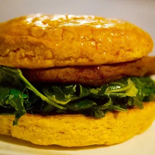 Southern fried pork cutlet and braised collards on a honey glazed sweet potato biscuit