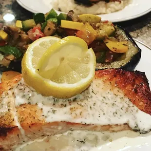 Salmon with lemon and dill cream sauce served with ratatouille stuffed eggplant boats
