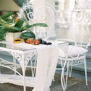 Sweetheart Table and Chairs. Antique White Wrought Iron Peacock Chairs. Matching Glass Table. Garden Party. Victorian Style. White Pillows.