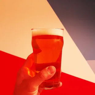 a hand holding a glass of beer