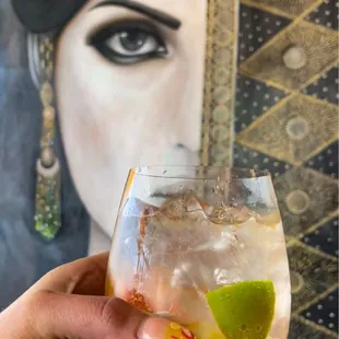 a hand holding a glass of cocktail