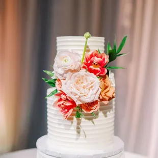 a wedding cake with flowers on top