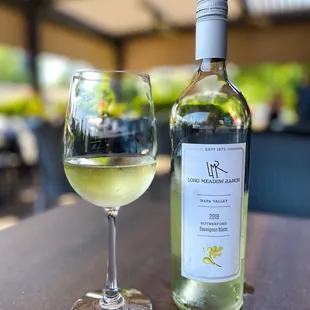 a glass of white wine and a bottle of wine