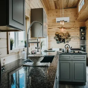 Cabinets and Corner Shelf provided by AMC in The Tiny Home Co.&apos;s Tiny House!