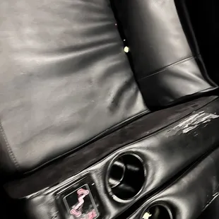 Greasy seats with trash in cup holders and popcorn scattered through the entire row