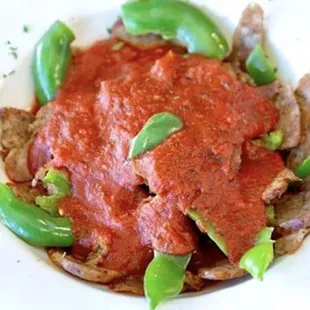 a plate of meat and peppers