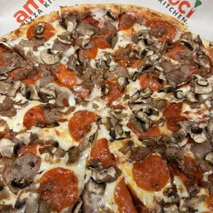 Pizza with pepperoni, sausage, and mushrooms