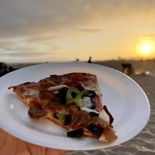 a slice of pizza on a paper plate