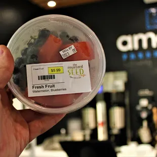  hand holding a container of fresh fruit