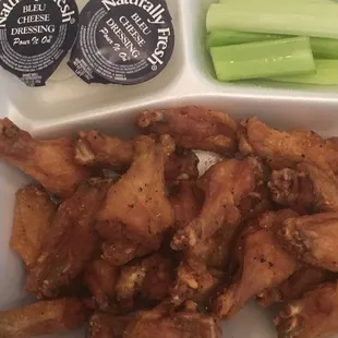 a tray of chicken wings and celery