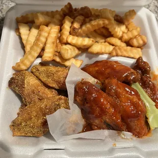 chicken wings and french fries in a styrofoam container