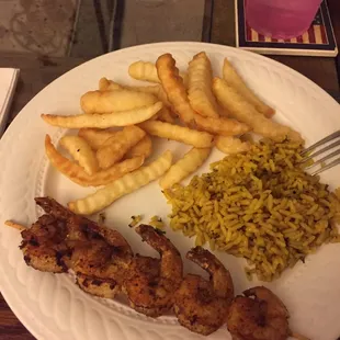 (Put onto plate at home for eating) grilled lemon pepper shrimp, fries, rice