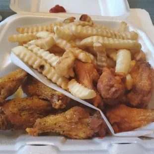 a tray of chicken wings and french fries