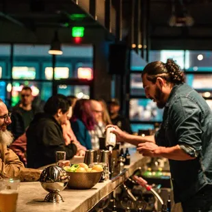 a bartender serving customers at a bar