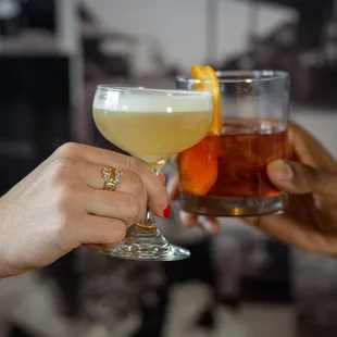 two people toasting with drinks