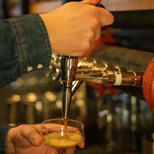 a person pouring a drink at a bar