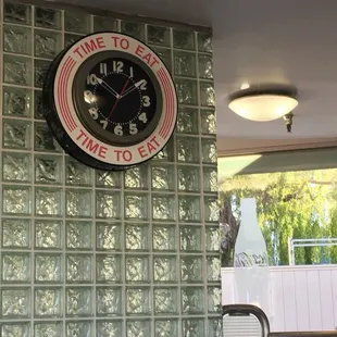 a clock on a glass block wall