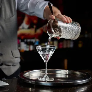 a bartender pouring a martini