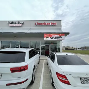 two cars parked in front of a deli