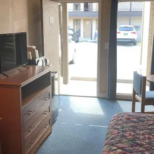 Open air motel with table chairs and tv