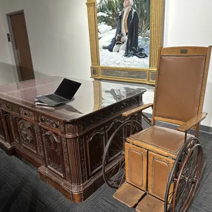 FDR's wheelchair and a mockup of the desk from the White House used in the movie JFK.