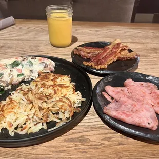 Veggie egg white omelet with shredded hash browns, bacon and ham on the side w/ OJ