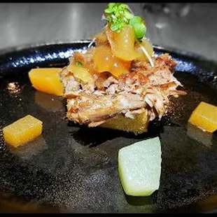 Anson Mills Grit Cake is topped with pork confit, smoked cheddar and apple marmalade.