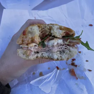 a person holding a half eaten sandwich