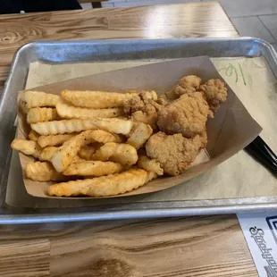Kids item - popcorn chicken with fries on a tray.