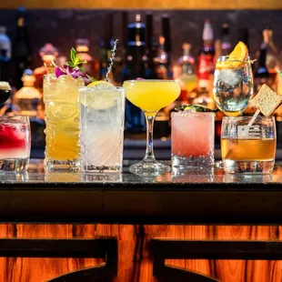 a variety of cocktails on a bar