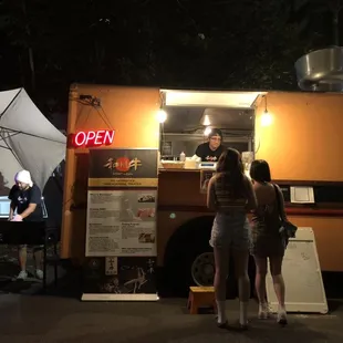 a woman ordering food from a food truck