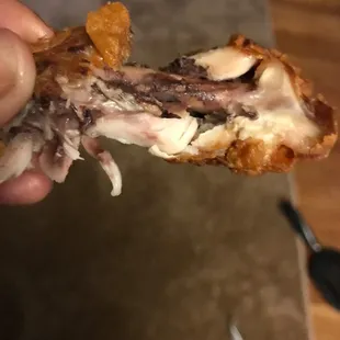 a hand holding a half eaten sandwich