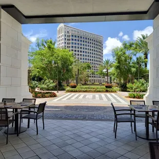 a view of a courtyard with tables and chairs