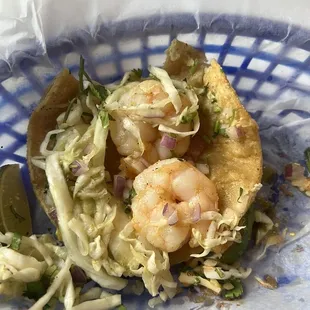 a taco with shrimp and coleslaw