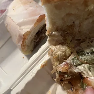 a half eaten sandwich in a styrofoam container