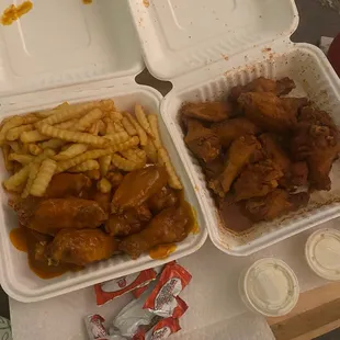 a tray of chicken wings, french fries, and ketchup