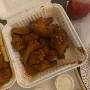a tray of chicken wings and fries