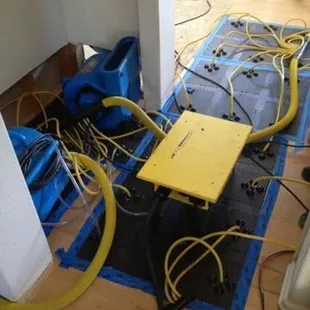 Hardwood floor has water being extracted by Injecti-dry