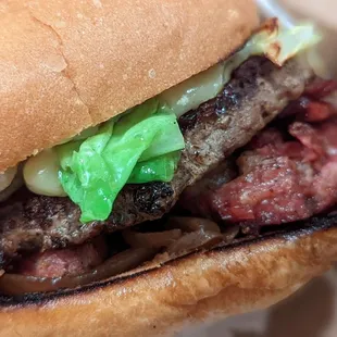 a hamburger with lettuce and onions