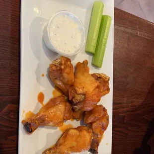 a plate of chicken wings and celery sticks