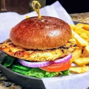 Grilled Chicken Panini chicken breast topped with lettuce, tomato and onion on a toasted brioche bun.