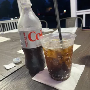 a cold drink and a coke on a table