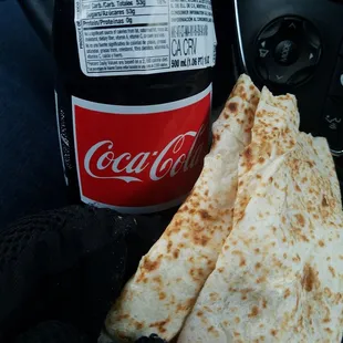 a hand holding a piece of quesadilla