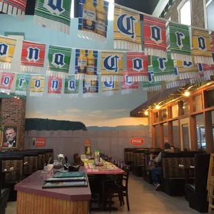 the interior of a restaurant with banners hanging from the ceiling